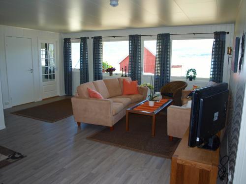 a living room with a couch and a tv at Hansnes Havfiske in Hansnes