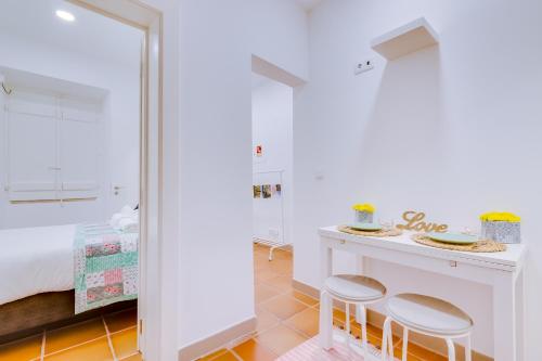 リスボンにあるCasa da Saudade, a cozy new apartmentのベッドルーム1室(ベッド1台、テーブル、スツール2脚付)