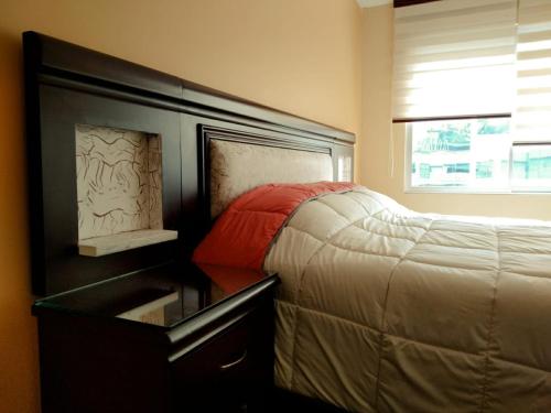 a bedroom with a bed next to a dresser and a window at Meraki in La Paz