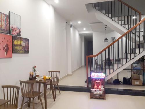 a dining room with a table and a staircase at candyinn in Hue