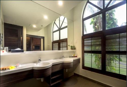 a large bathroom with two sinks and a large window at Tanjung Puteri Golf and Resort Malaysia in Pasir Gudang