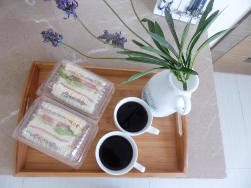 a tray with a sandwich and two cups of coffee at La View 麗晨 Homestay in Manzhou