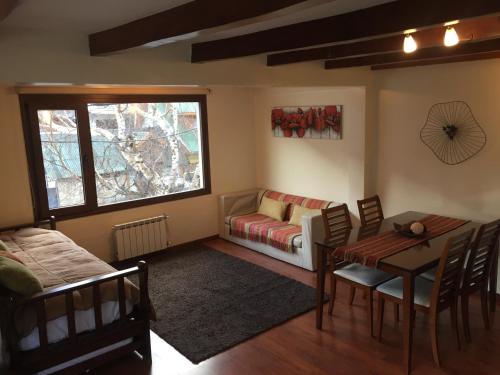 sala de estar con sofá y mesa en Abedul Apartamentos en San Martín de los Andes