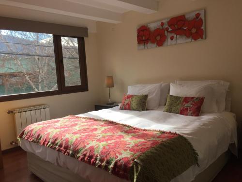 sypialnia z dużym białym łóżkiem i oknem w obiekcie Abedul Apartamentos w mieście San Martín de los Andes