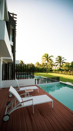 a deck with two chairs next to a swimming pool at Mareazul Beach Front Condos At playa del Carmen in Playa del Carmen