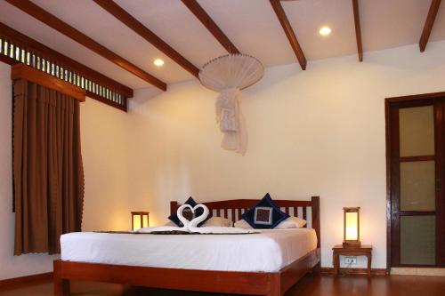 a bedroom with a bed with a fan on the wall at Tadlo Lodge in Ban Nongtoung