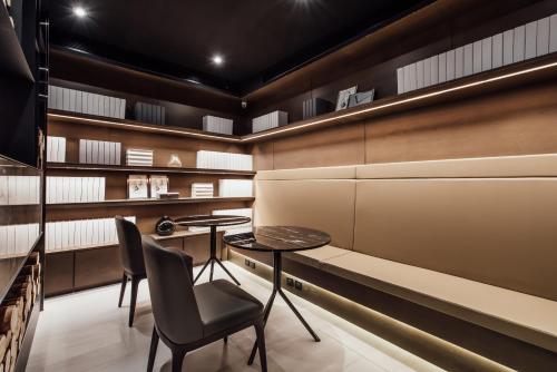 a room with a table and chairs and shelves at Harbour 10 Hotel in Kaohsiung