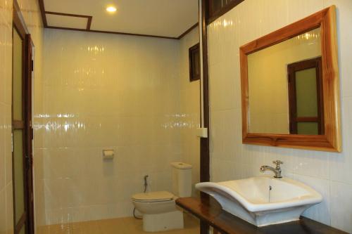 a bathroom with a sink and a toilet and a mirror at Tadlo Lodge in Ban Nongtoung