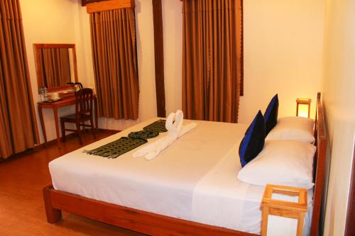 a hotel room with a bed with towels on it at Tadlo Lodge in Ban Nongtoung