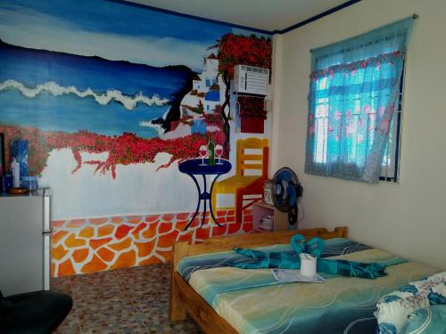 a bedroom with a bed with a painting on the wall at Bolo Beach Santorini nearby to Hundred Island in Alaminos