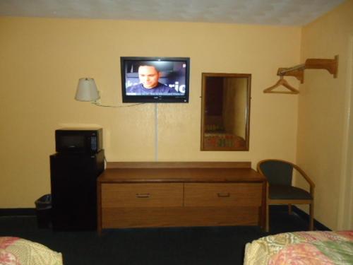 a tv on a wall in a hotel room at Relax Inn in Fisherville