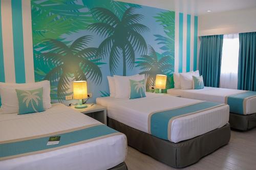 a bedroom with two beds with palm trees on the wall at Maayo Argao in Argao
