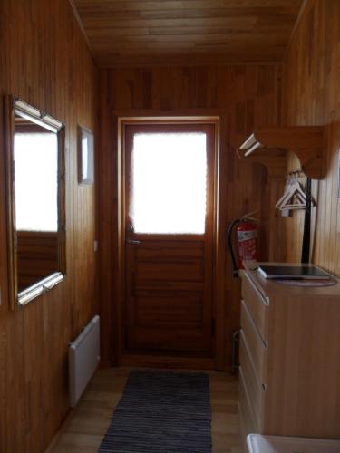 a small room with a door and a refrigerator at Ekra Cottages in Lagarfljótsvirkjun
