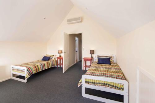 a bedroom with two beds and a table and a door at The Loft in Paynesville