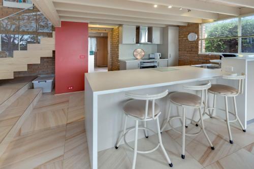 a kitchen with a white counter and stools at Getaway in Paynesville
