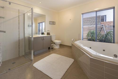 a bathroom with a tub and a shower and a toilet at Pelican Landing in Paynesville