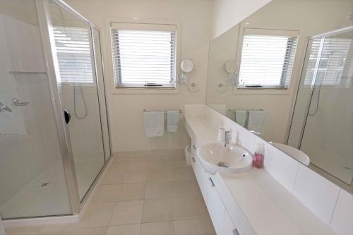 a white bathroom with a sink and a shower at Beach 2 in Paynesville
