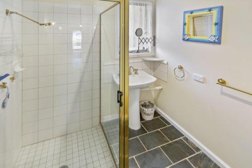 a bathroom with a shower and a sink at Cedar Cottage in Raymond Island