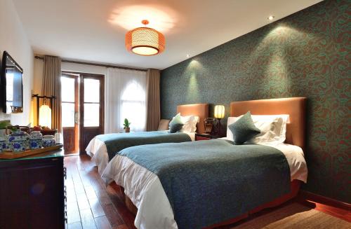 duas camas num quarto com paredes verdes em Jingshan Garden Hotel em Pequim