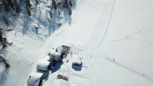 an aerial view of a snow covered road with cars at Hotel Ristorante Lagrev in Maloja
