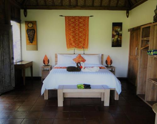 a bedroom with a bed with a cat sitting on it at Bali Sawah Indah in Ubud