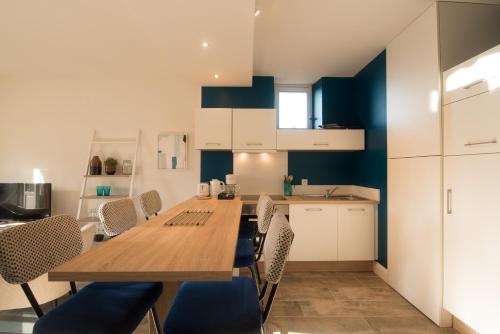 une cuisine avec une table et des chaises en bois dans l'établissement La Belle Terrasse avec climatisation et parking privé, à Sarlat-la-Canéda