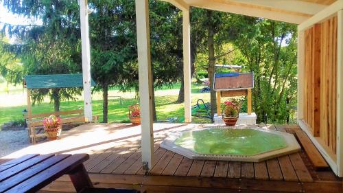 a hot tub on a wooden deck with a bench at Kristály Vendégház in Bogács