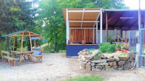 a small house with a table and a tent at Kristály Vendégház in Bogács