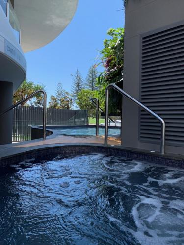 een zwembad met metalen relingen in een huis bij Breeze Mooloolaba, Ascend Hotel Collection in Mooloolaba