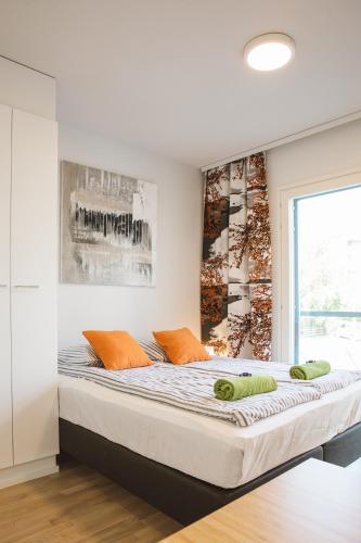 a bedroom with a large bed with orange pillows at First aparthotel Blitzen in Rovaniemi