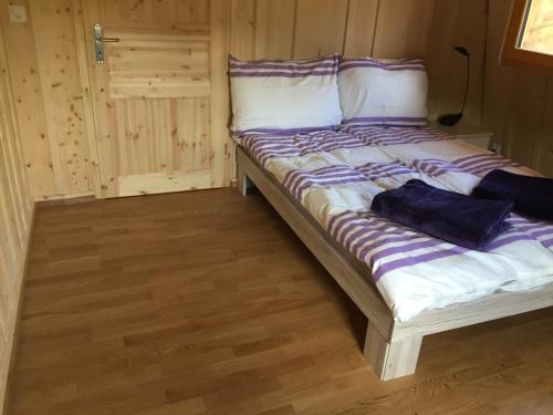 a bed with a purple and white comforter in a room at Chez Dodo 2534 Orvin Le Foncet in Evilard
