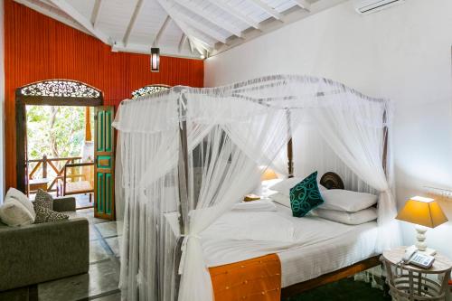 a bedroom with a bed with a canopy at Thambapanni Retreat in Unawatuna