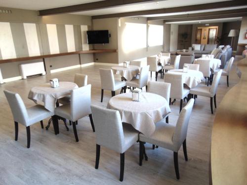 a dining room with white tables and chairs at Plus Welcome Milano in Milan