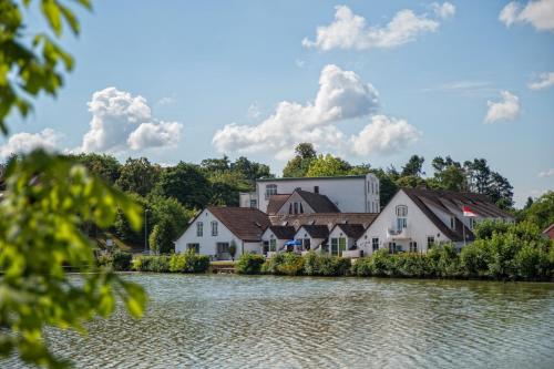 ein Dorf am Wasser mit einem großen Gebäude in der Unterkunft Thomasmühle Ferienwohnungen in Leutershausen