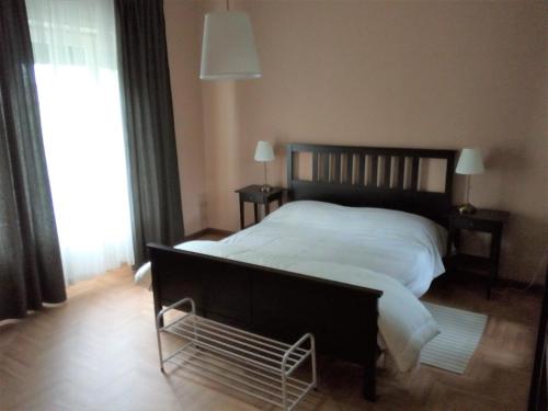 een slaapkamer met een bed met witte lakens en een raam bij Da Nerina in Cormòns