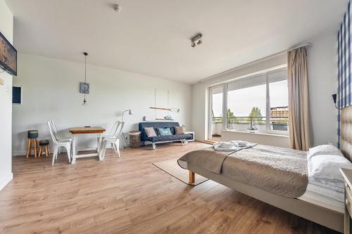 1 dormitorio con 1 cama, mesa y sillas en Apartamenty Sun & Snow Etna, en Kołobrzeg