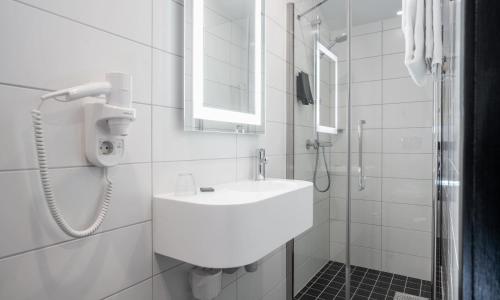 a white toilet sitting next to a shower in a bathroom at Thon Hotel Astoria in Oslo