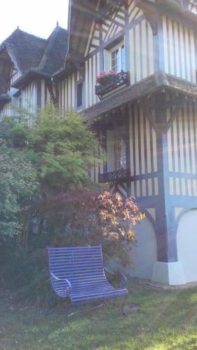 a blue bench sitting in front of a house at Maison d'hôtes Il était une fois in Pont-lʼÉvêque