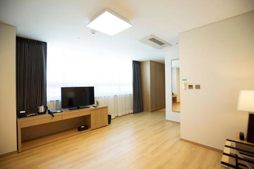 a living room with a flat screen tv on a table at Best Western Haeundae Hotel in Busan