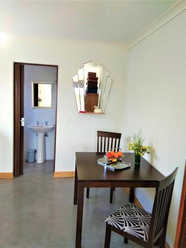 a dining room with a table and chairs and a mirror at Spectrum of views near Muizenberg in Lakeside