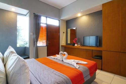 ein Schlafzimmer mit einem Bett mit zwei Schwänen darauf in der Unterkunft Sayang Residence 2 in Denpasar
