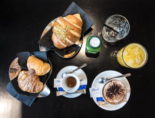 ナポリにあるB&B Solimenaのペストリー、コーヒー、ドリンクの盛り合わせが備わるテーブル