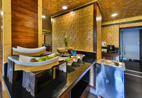 a kitchen with two sinks and a counter with bowls of fruit at Royal Grandiose Pahalgam in Pahalgām