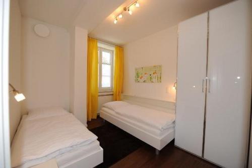 a small bedroom with two beds and a window at Ferienwohnung-Am-Kurpark-Wohnung-1-60qm in Garmisch-Partenkirchen
