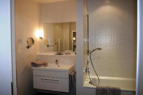 a bathroom with a shower and a sink and a tub at Ferienwohnung-Am-Kurpark-Wohnung-1-60qm in Garmisch-Partenkirchen