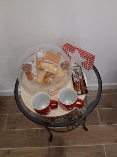 a glass table with a plate of food and two cups at H.Albar Mieres in Mieres