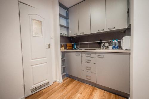 a kitchen with white cabinets and a white door at FUDA APARTAMENT DZIECI WRZESIŃSKICH 6/1/1 in Gorzów Wielkopolski