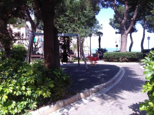 a park with a swing set under a tree at Casa Rosa appartamento con giardino in Cetara