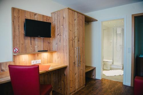 a room with a desk with a television on a wooden wall at Gasthaus Stroh in Buchholz