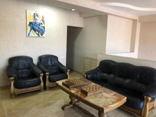 a living room with a leather couch and chairs at The K Tbilisi in Tbilisi City